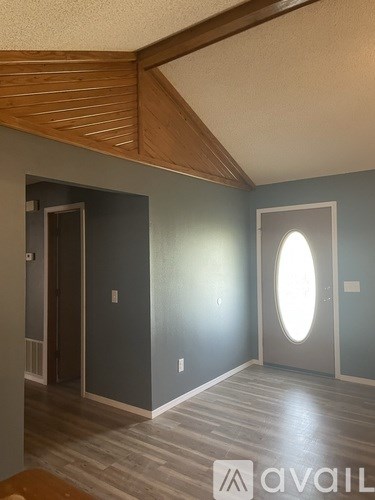 A room with a wooden ceiling and a round window.