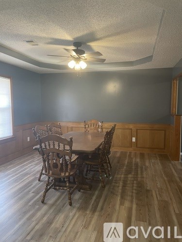 A dining room with a wooden table and chairs.