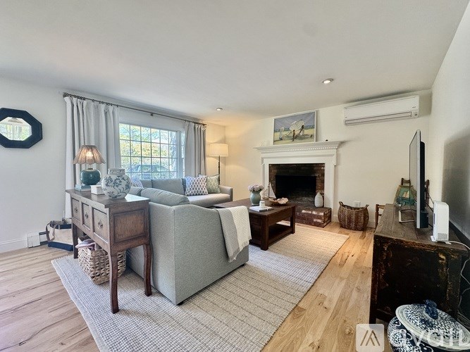 A living room with a grey couch, a fireplace, and a television.
