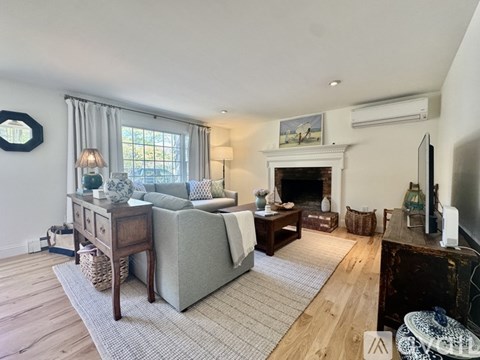 A living room with a grey couch, a fireplace, and a television.