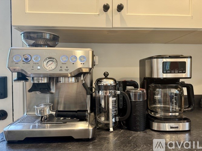 A coffee machine and a coffee grinder are on a counter.