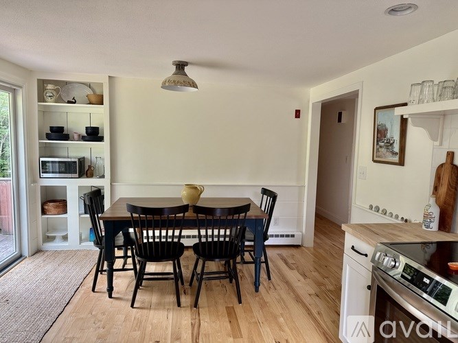 A kitchen with a dining table and chairs.