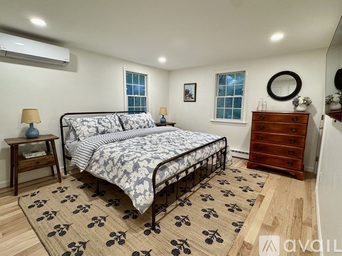 A bedroom with a bed, dresser, and nightstand.