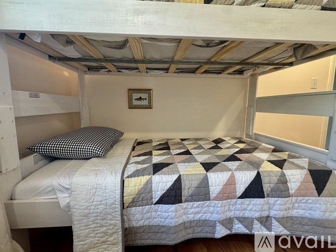 A bedroom with a bed and a quilt on the bed.