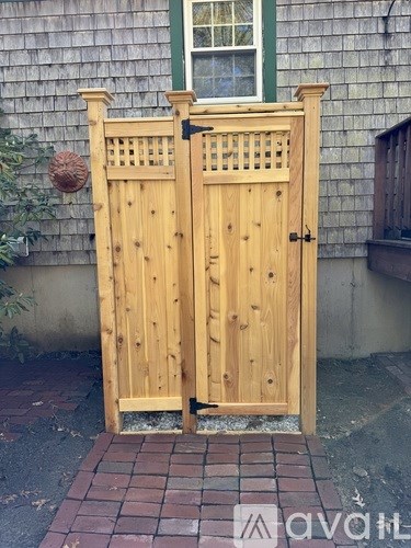 A wooden gate with a green window in the background.