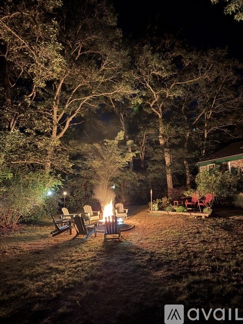 A backyard with a fire pit and chairs.
