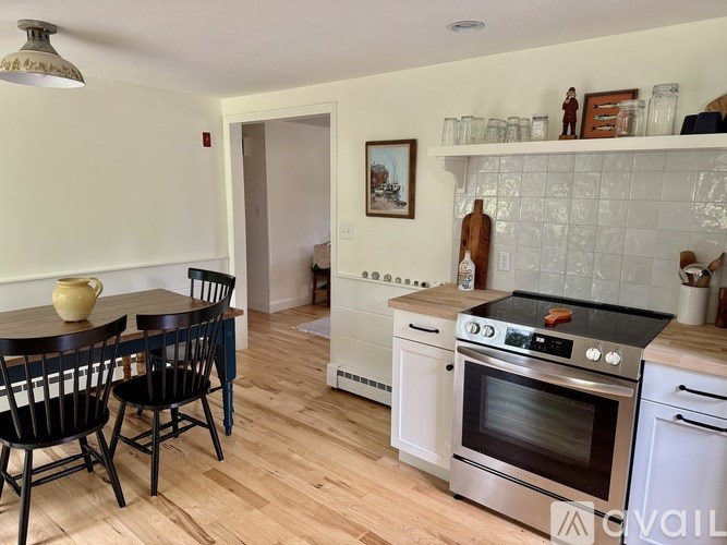 A kitchen with a white tile backsplash and a stainless steel oven.