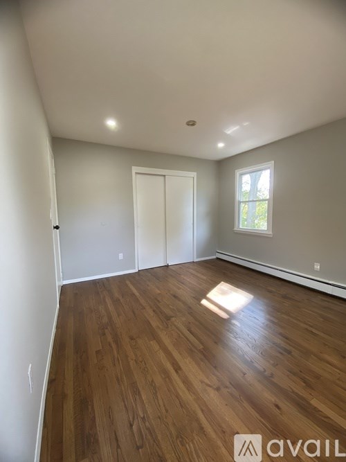 A room with wooden flooring and a window.