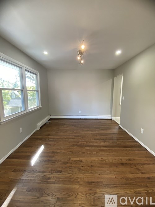 A room with wooden flooring and a chandelier.