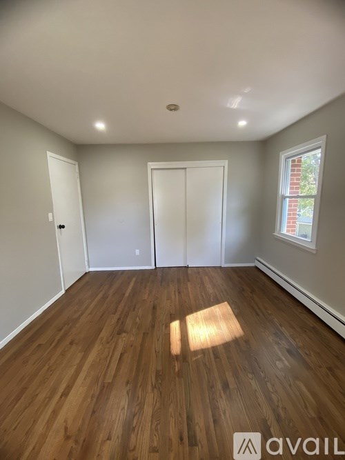 A room with wooden floors and two white doors.