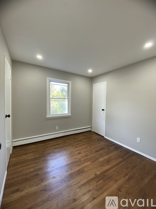 A room with wooden floors and a window.