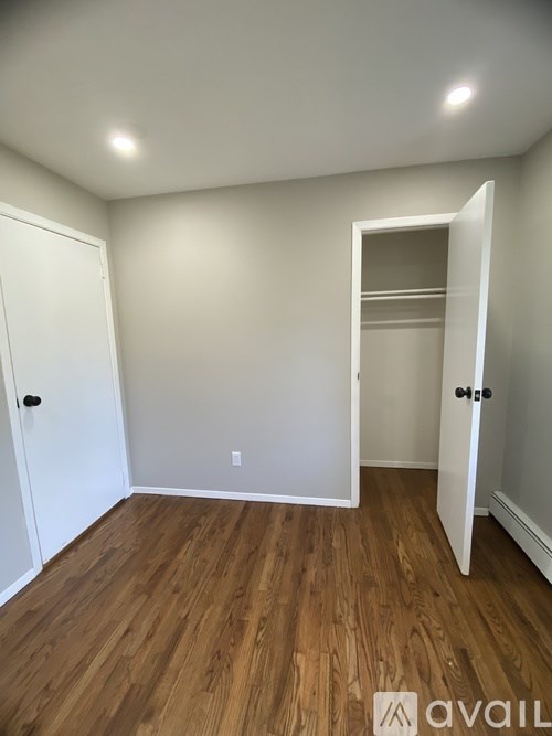 A room with a white door and a white closet with a shelf.