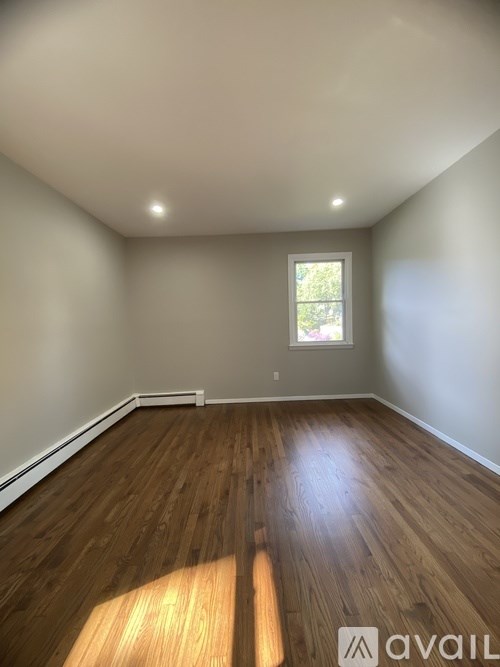 A room with wooden flooring and a window.