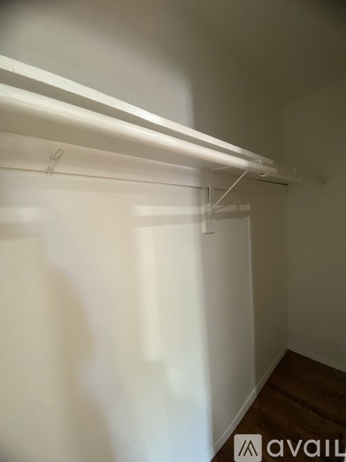 A white wall with a long white shelf on top.