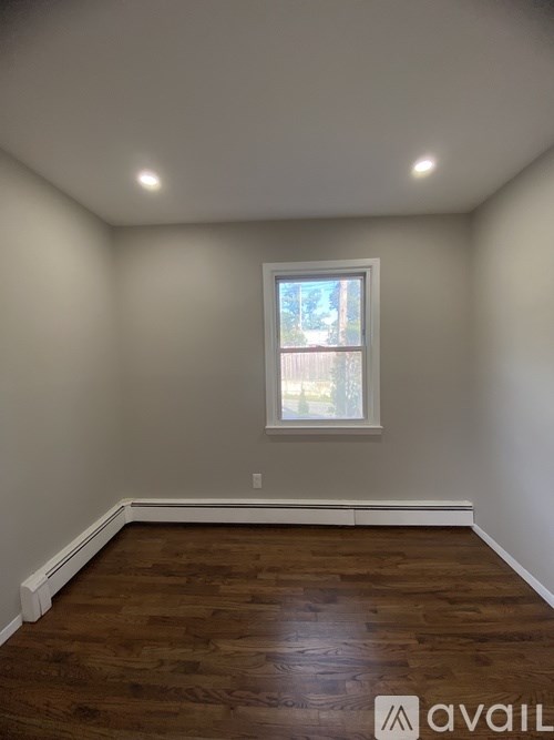 A room with a window and wooden floors.