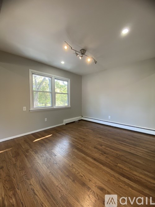A room with wooden flooring and a window.