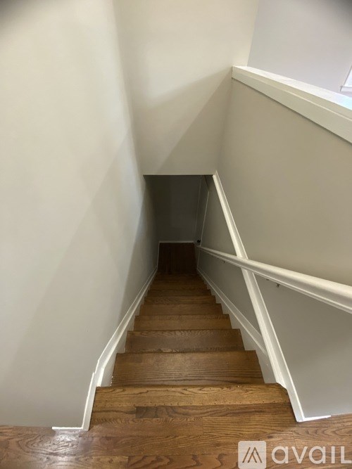 A staircase with wooden steps and white railings.