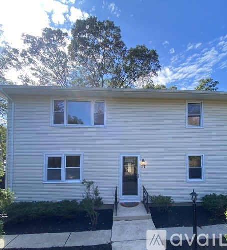 A house with a front yard and a black lamp post.