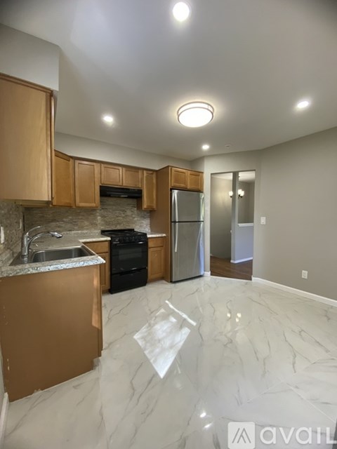 A kitchen with marble flooring and wooden cabinets.