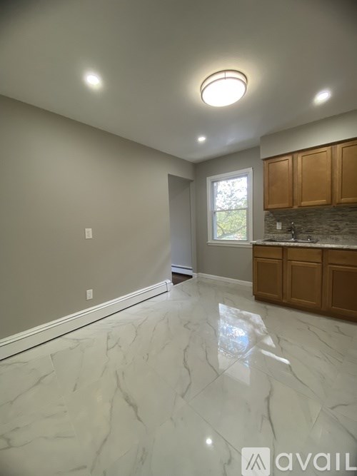 A room with marble flooring and wooden cabinets.
