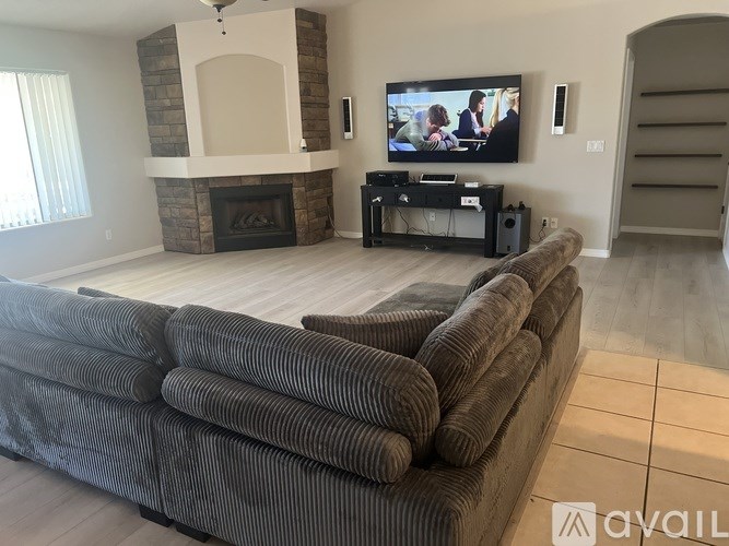 A living room with a couch, television, and fireplace.