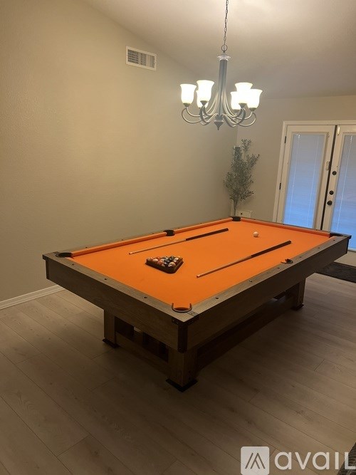 A pool table with a green plant on the side.