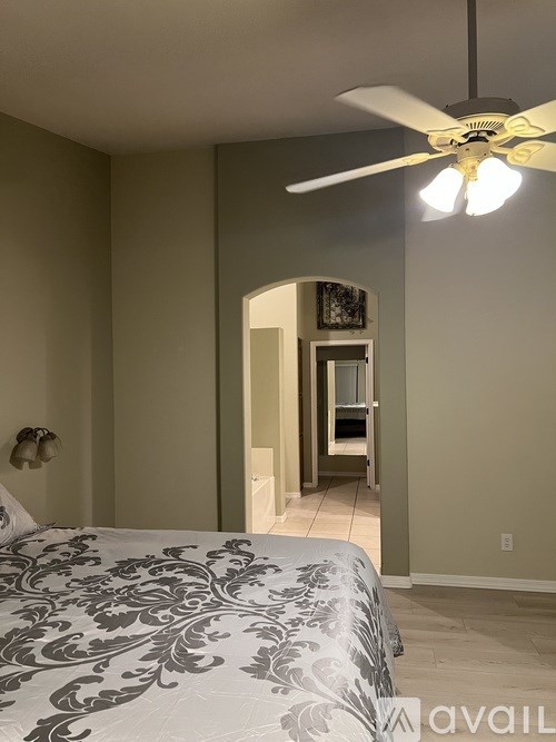 A bedroom with a bed and a ceiling fan.