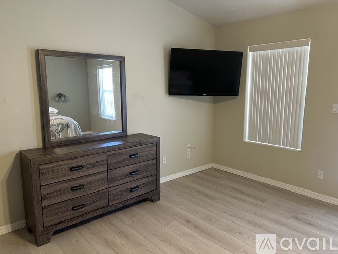 A bedroom with a dresser and a mirror.