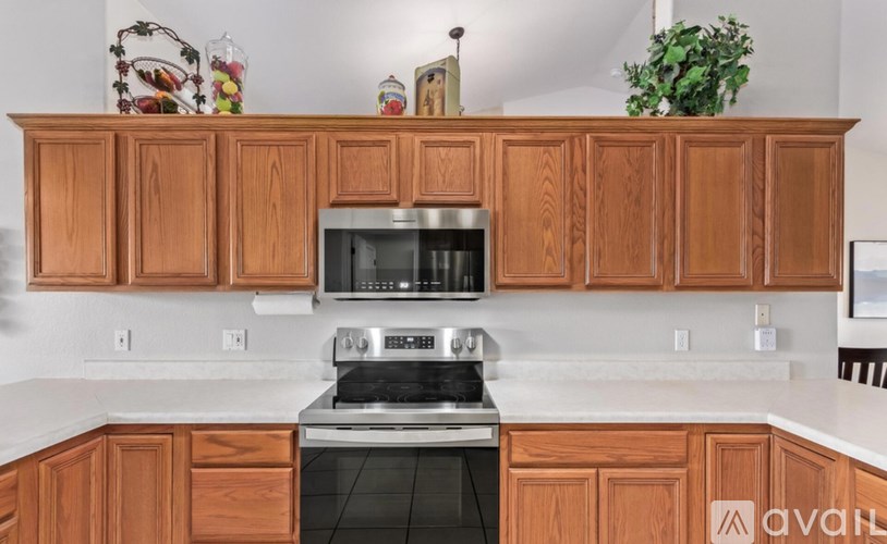 A kitchen with wooden cabinets and a stainless steel stove.