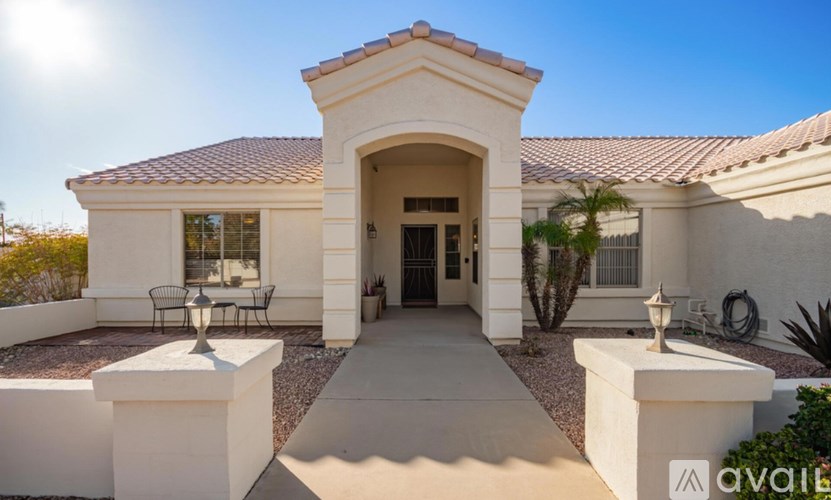A white house with a red tile roof and a covered patio area.