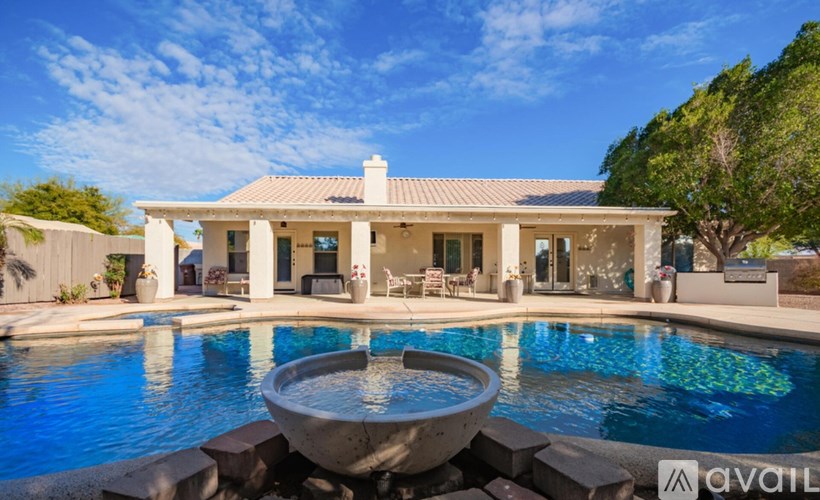 A house with a pool in front of it.