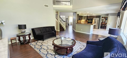 A living room with a black couch and a coffee table.