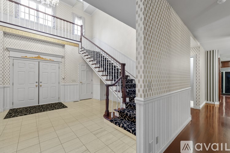 A hallway with a staircase and a door.