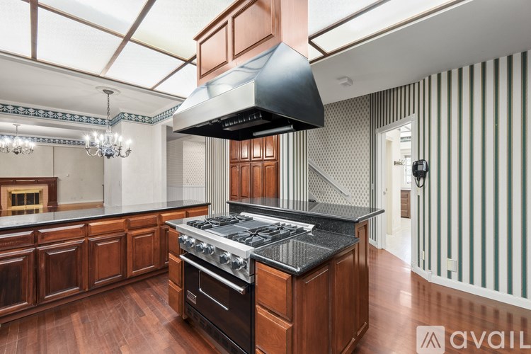 A kitchen with wooden cabinets and a black range hood.