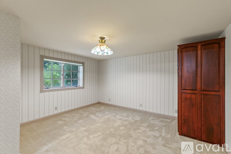 A room with a wooden door and a window with blinds.