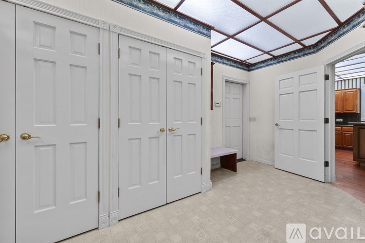 A room with white doors and a bench in the middle.