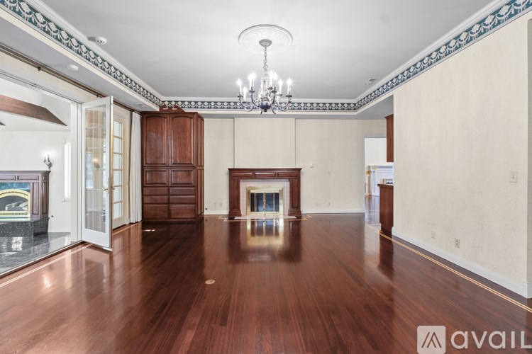 A large empty room with wooden floors and a chandelier.
