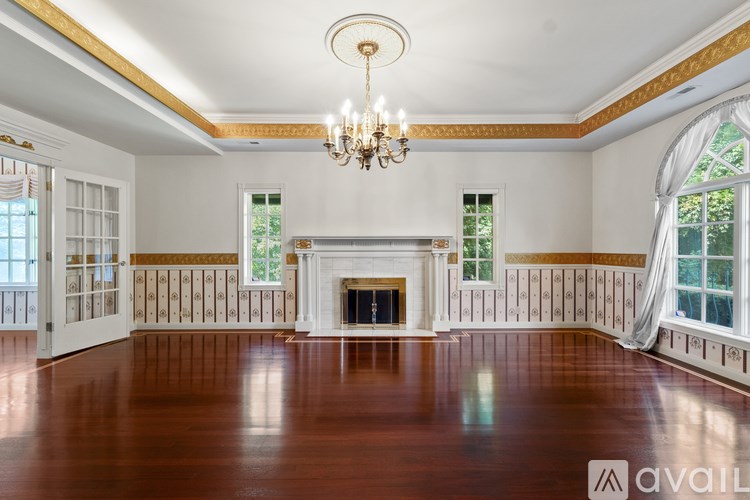 A large, empty room with a fireplace and a chandelier.
