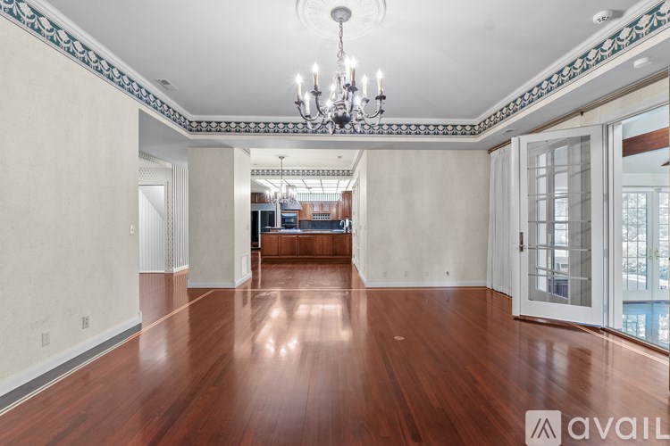 A large empty room with wooden floors and a chandelier.