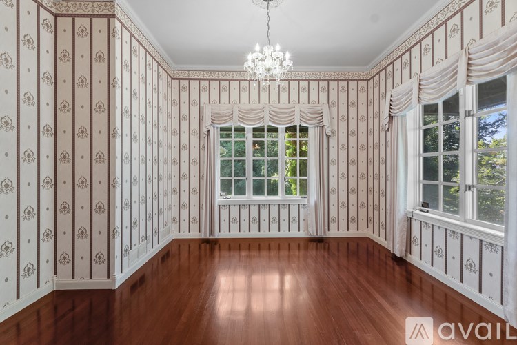 A room with a wooden floor and a chandelier hanging from the ceiling.