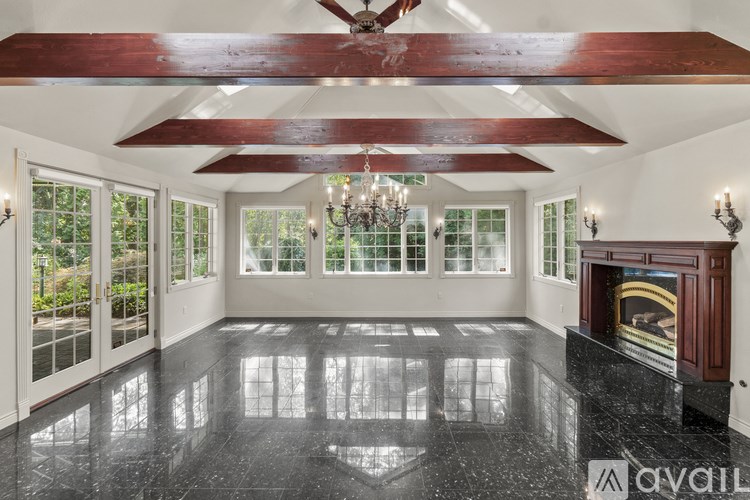A large, well-lit room with a fireplace and a chandelier.
