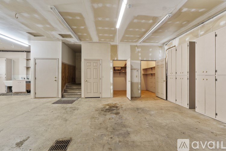A large, empty storage room with white cabinets and a concrete floor.