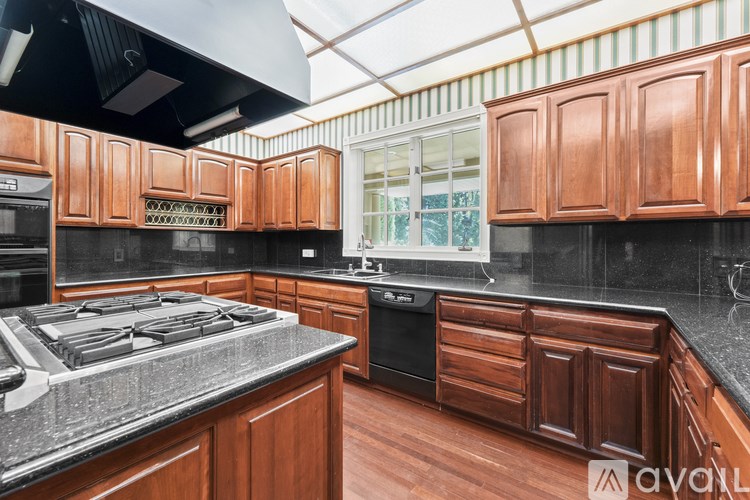 A kitchen with wooden cabinets and black countertops.