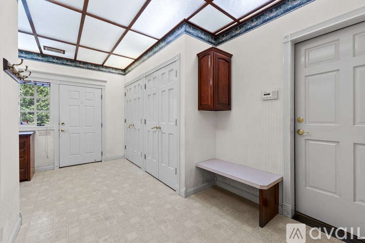 A room with a bench, cupboards and a door.