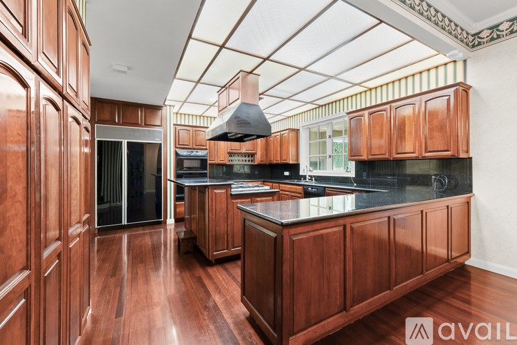 A kitchen with wooden cabinets and a black countertop.