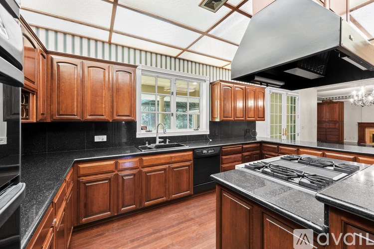 A kitchen with wooden cabinets and a black countertop.