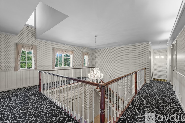 A staircase with a black and white patterned carpet.