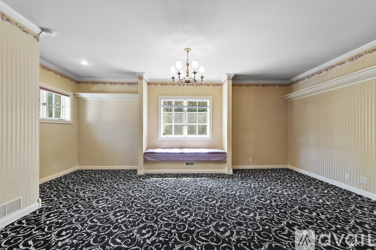 A room with a chandelier, a bench, and a window.