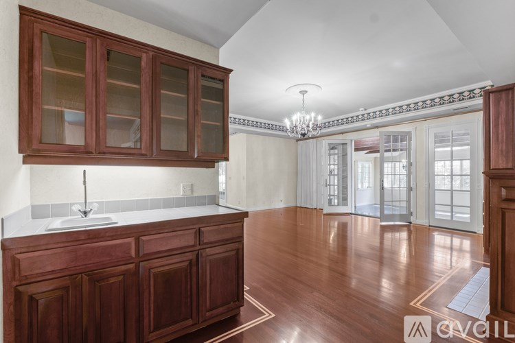 A kitchen with wooden cabinets and a chandelier.