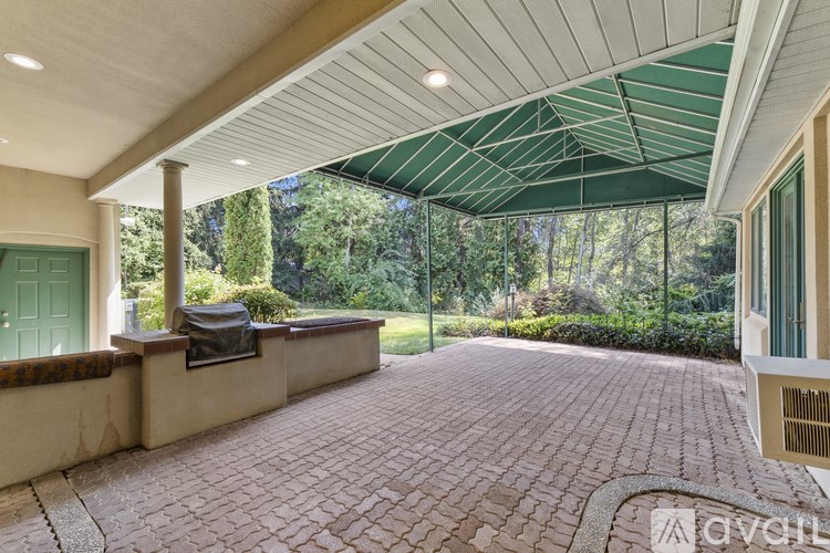 A patio with a green awning and a brick floor.